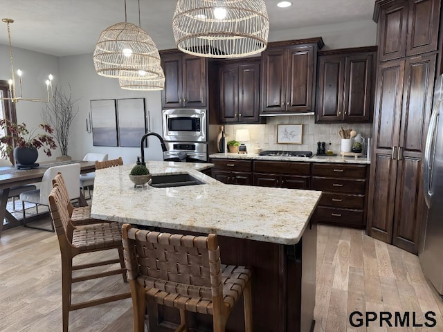 kitchen featuring pendant lighting, sink, built in appliances, and a spacious island