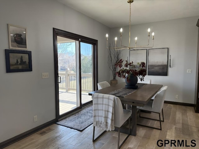 dining area with a notable chandelier and light wood-type flooring