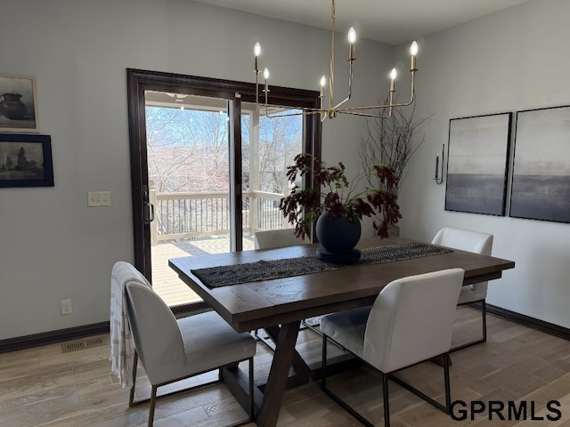 dining room featuring an inviting chandelier and light hardwood / wood-style flooring