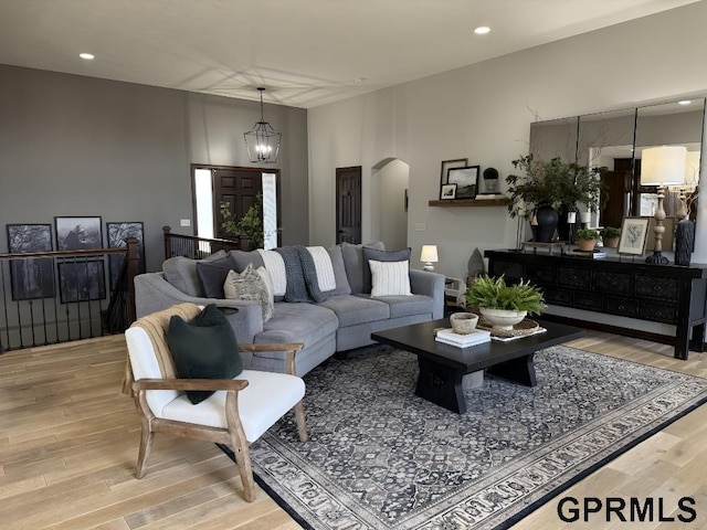 living room with a chandelier and light wood-type flooring