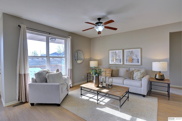 living room with ceiling fan and light wood-type flooring