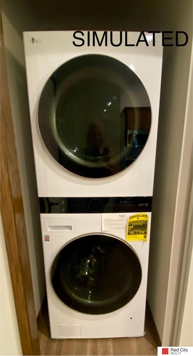 laundry room with wood-type flooring and stacked washer and clothes dryer