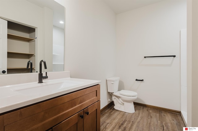 bathroom featuring wood-type flooring, vanity, and toilet