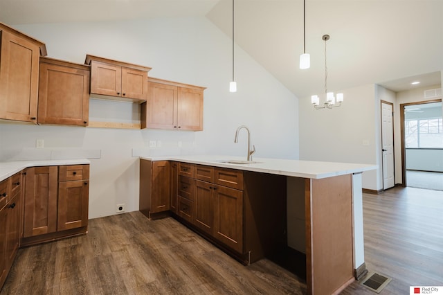 kitchen featuring pendant lighting, sink, dark hardwood / wood-style flooring, and high vaulted ceiling