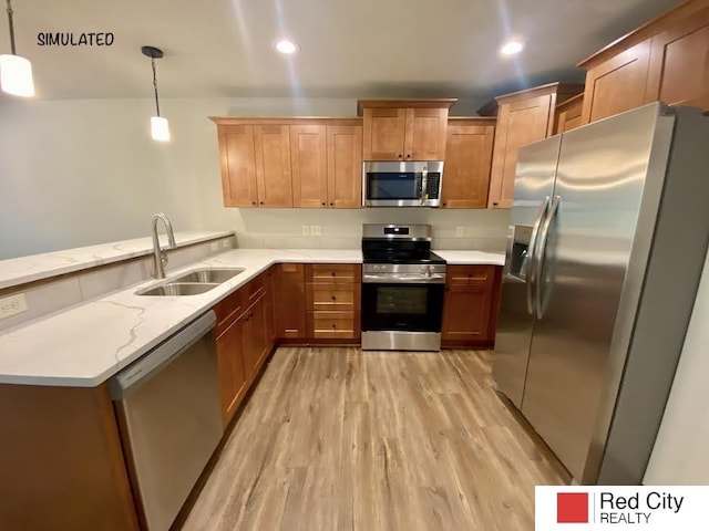 kitchen featuring sink, light stone counters, hanging light fixtures, light wood-type flooring, and stainless steel appliances