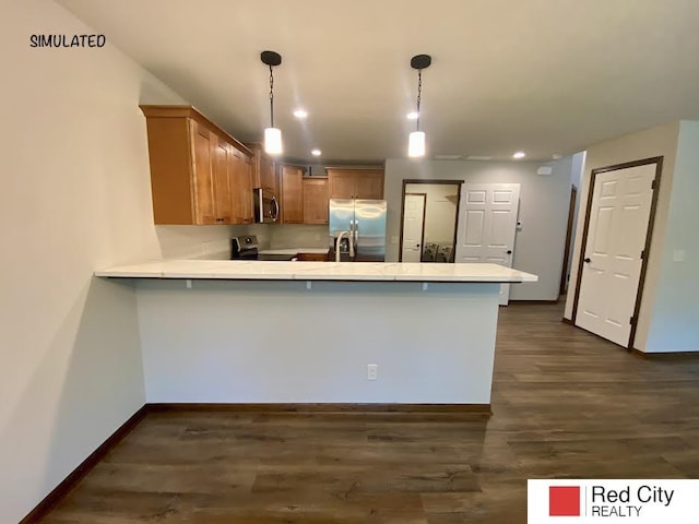 kitchen with appliances with stainless steel finishes, pendant lighting, dark hardwood / wood-style flooring, and kitchen peninsula