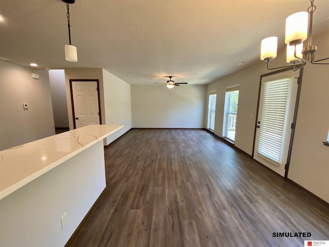 unfurnished living room with ceiling fan, a textured ceiling, and dark hardwood / wood-style flooring