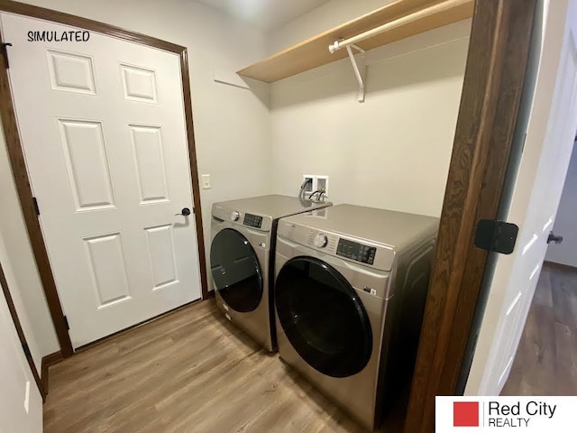 laundry room with independent washer and dryer and light wood-type flooring