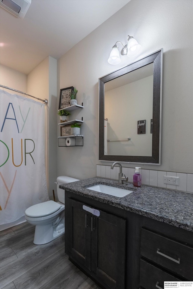 bathroom featuring vanity, wood-type flooring, and toilet