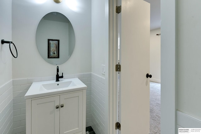 bathroom featuring vanity and tile walls