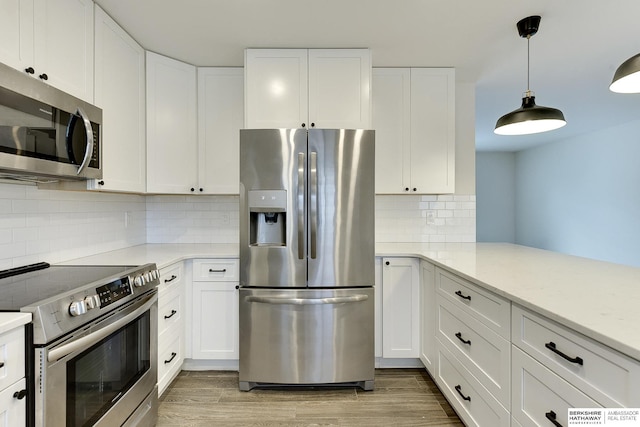 kitchen featuring light hardwood / wood-style flooring, hanging light fixtures, stainless steel appliances, tasteful backsplash, and white cabinets