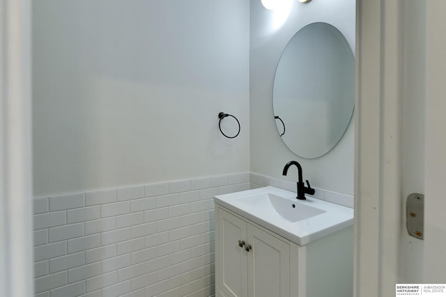 bathroom with vanity and tile walls