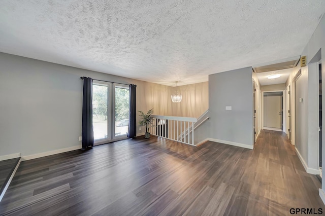 empty room with dark hardwood / wood-style flooring and a textured ceiling