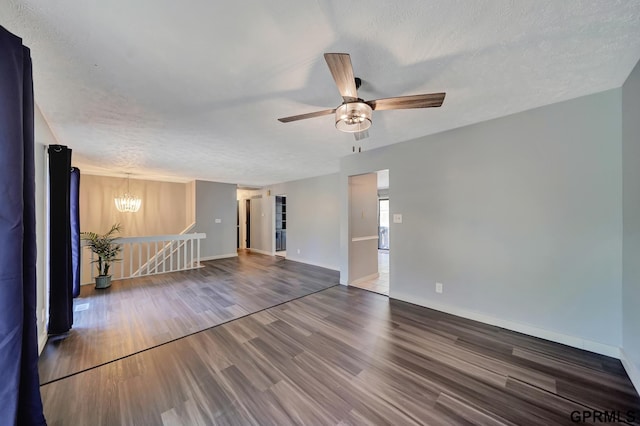 empty room with wood-type flooring, ceiling fan with notable chandelier, and a textured ceiling