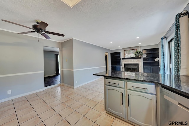 kitchen featuring stainless steel dishwasher, light tile patterned floors, a textured ceiling, and built in shelves