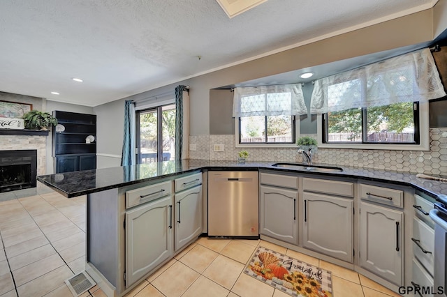 kitchen featuring sink, gray cabinetry, stainless steel dishwasher, light tile patterned floors, and kitchen peninsula