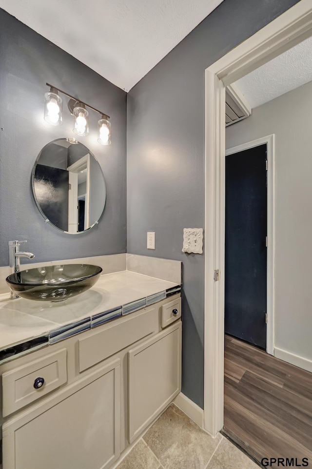 bathroom featuring vanity, hardwood / wood-style floors, and a textured ceiling