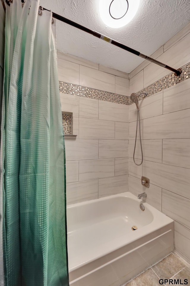 bathroom with shower / tub combo with curtain and a textured ceiling