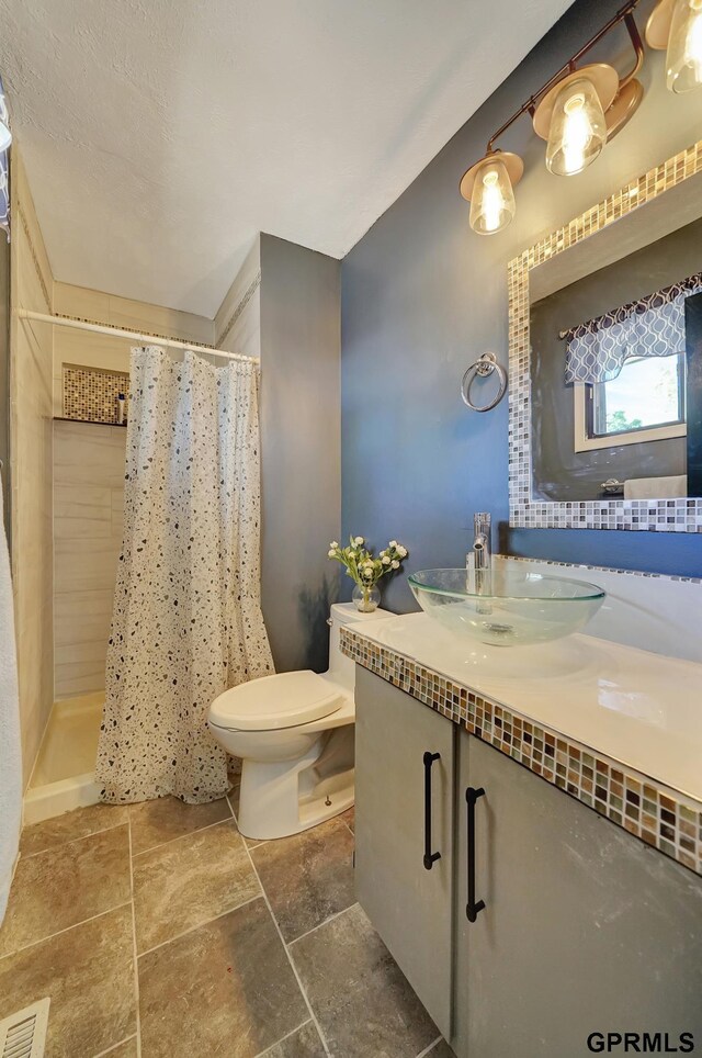 bathroom featuring toilet, vanity, and walk in shower