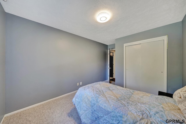 bedroom with a closet, carpet flooring, and a textured ceiling