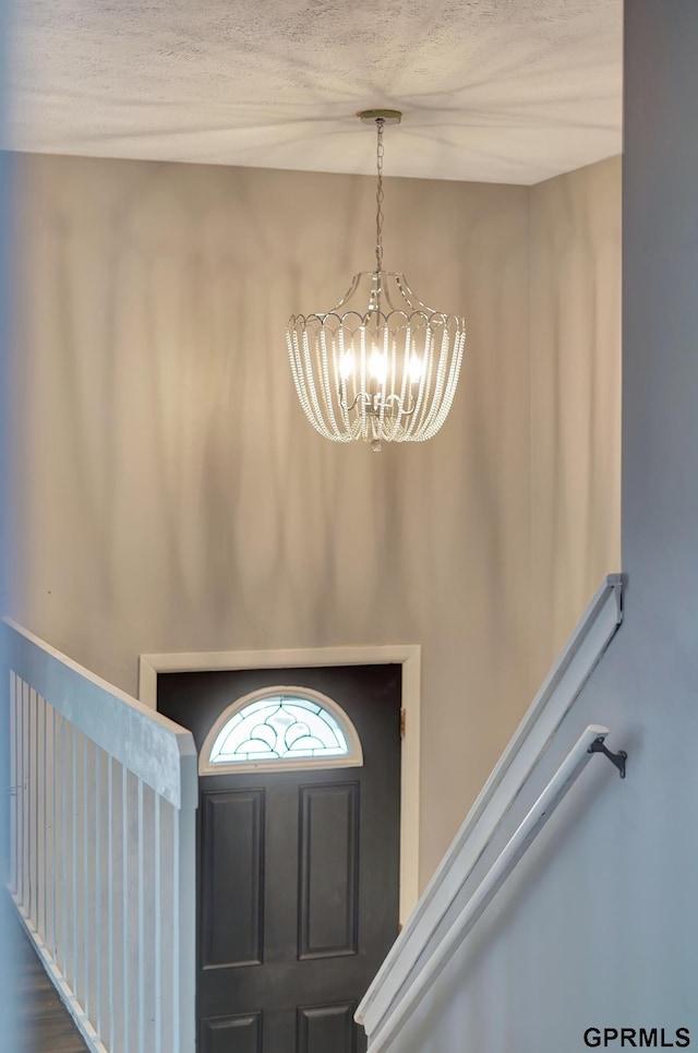 entrance foyer with a textured ceiling and a chandelier