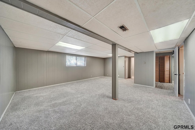 basement with carpet and a paneled ceiling