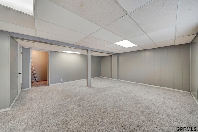 basement featuring carpet and a drop ceiling