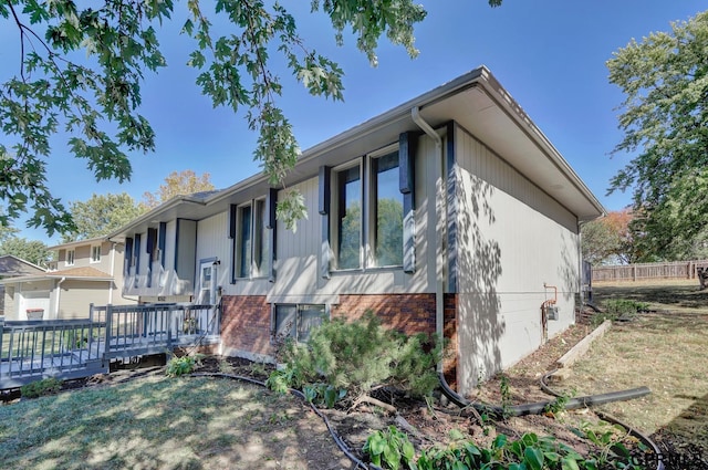 exterior space featuring a wooden deck and a front yard