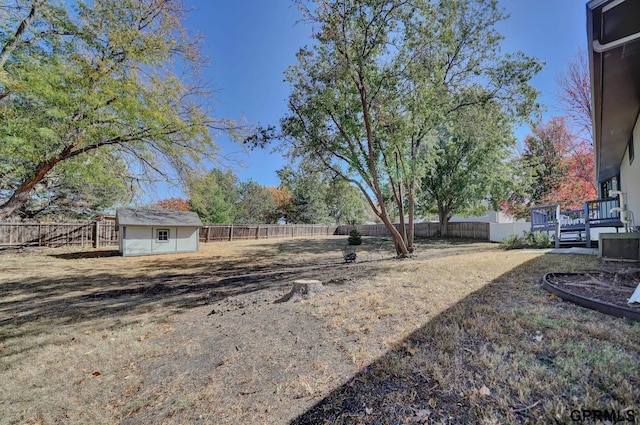 view of yard with a wooden deck and a storage unit