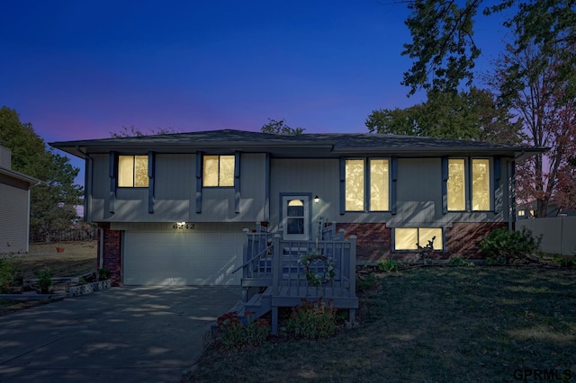 split foyer home with a garage and a lawn