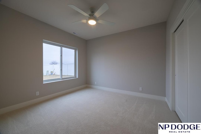 unfurnished bedroom featuring ceiling fan, light colored carpet, and a closet