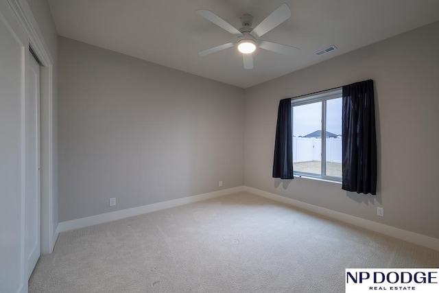 carpeted spare room with ceiling fan