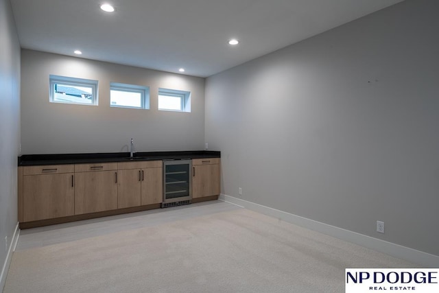 bar featuring sink, light colored carpet, and wine cooler