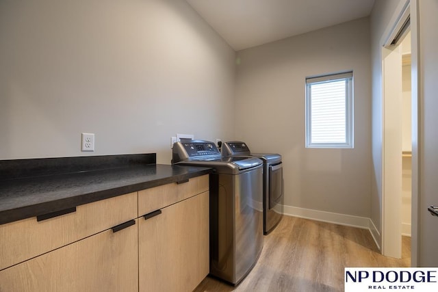 laundry area with cabinets, independent washer and dryer, and light wood-type flooring