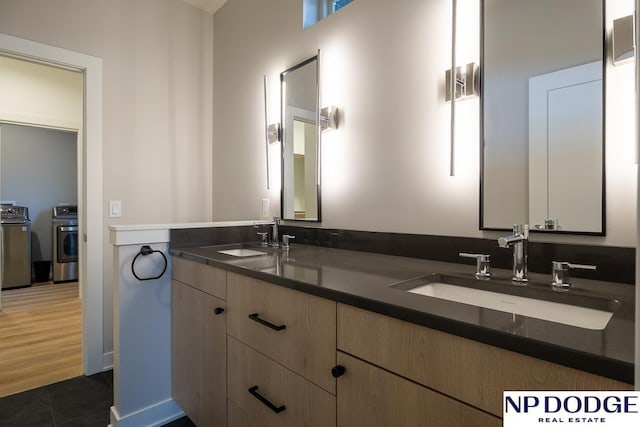 bathroom with vanity, tile patterned flooring, and washer and dryer