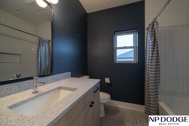 full bathroom with vanity, shower / bath combo with shower curtain, and toilet