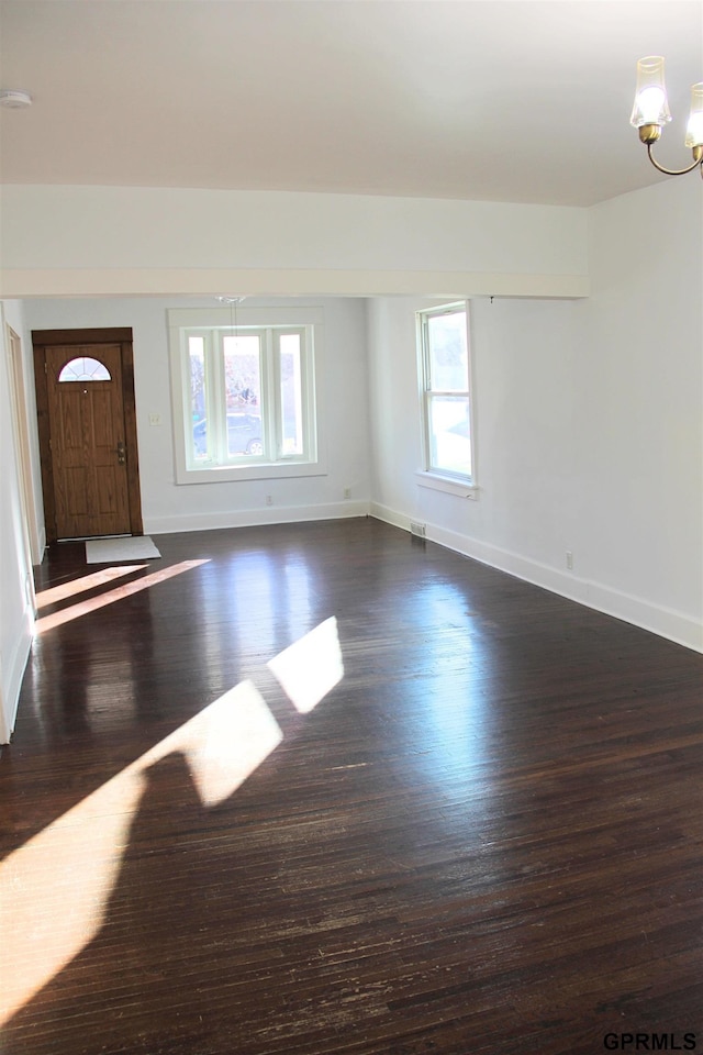 interior space with an inviting chandelier and dark hardwood / wood-style flooring