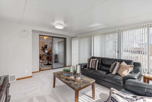 living area with visible vents, baseboards, and carpet flooring