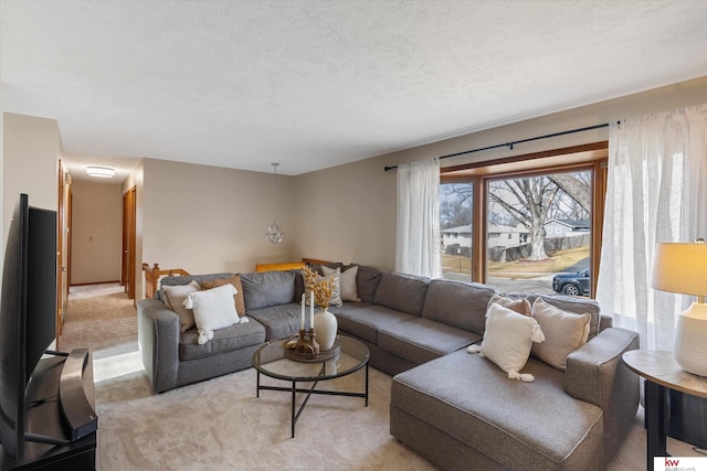 living area with light colored carpet and a textured ceiling