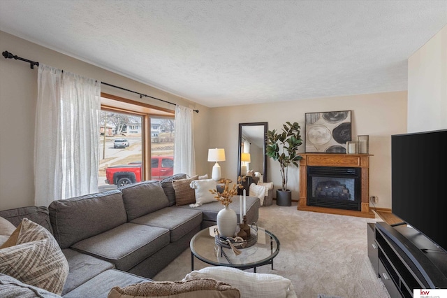 carpeted living room with a textured ceiling and a glass covered fireplace