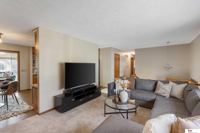 living room featuring baseboards, a textured ceiling, and light carpet