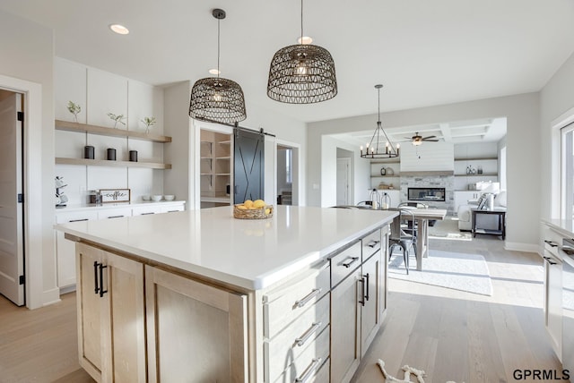 kitchen with white cabinetry, a barn door, and a kitchen island