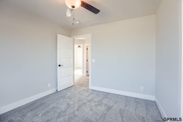 carpeted spare room with ceiling fan