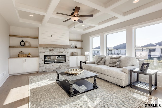 living room featuring coffered ceiling, beam ceiling, light hardwood / wood-style floors, and ceiling fan