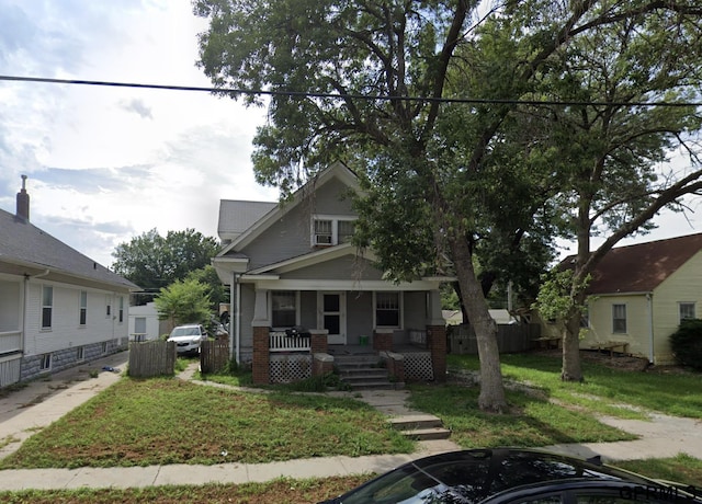 view of front of house with a porch and a front yard