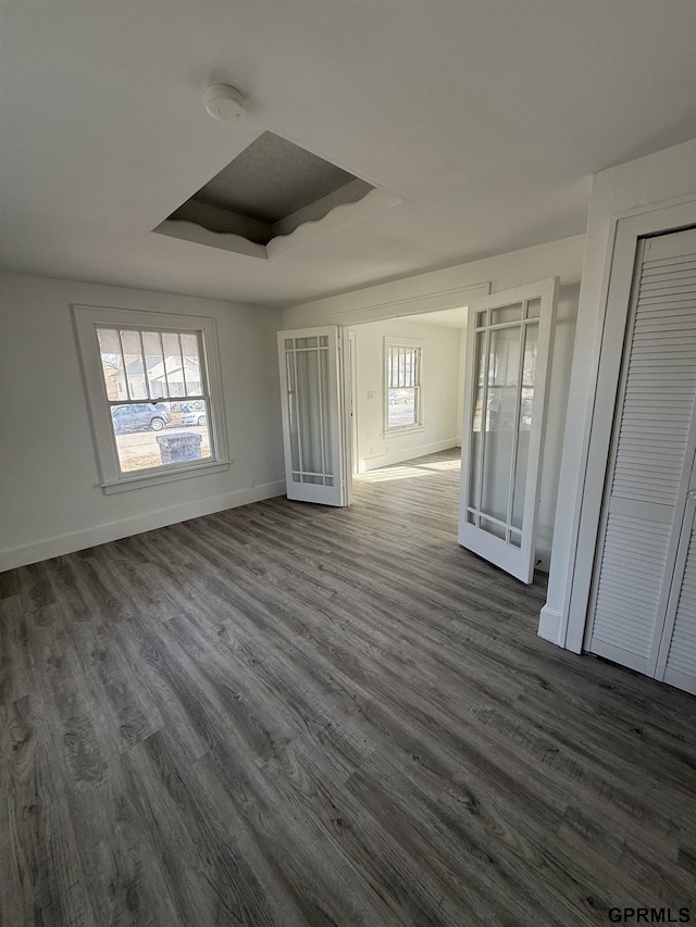 interior space with dark hardwood / wood-style floors and a raised ceiling