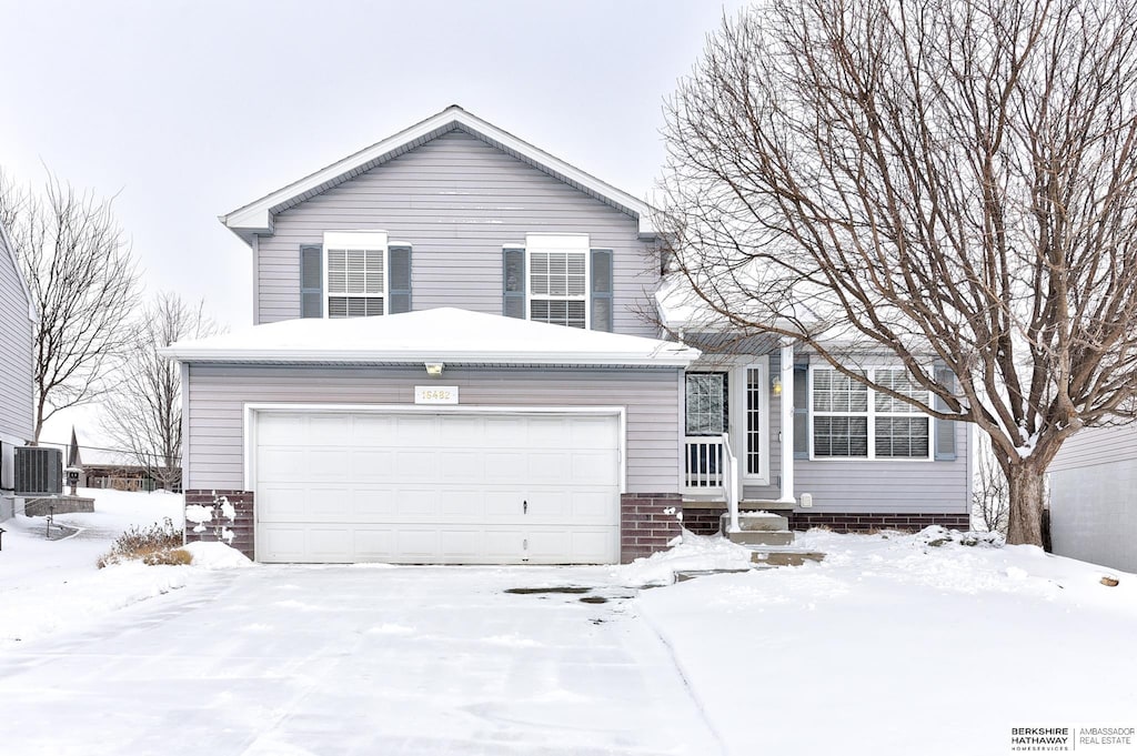 view of front facade featuring a garage and cooling unit