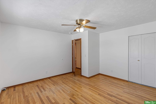 unfurnished bedroom featuring ceiling fan, a textured ceiling, light wood-type flooring, and a closet