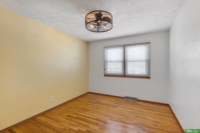 empty room featuring light hardwood / wood-style floors and a textured ceiling