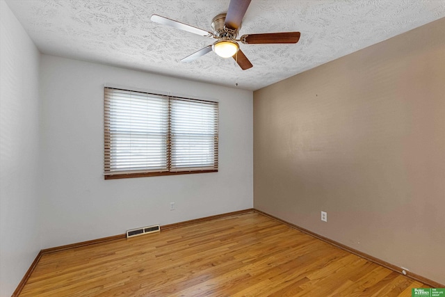 empty room featuring ceiling fan, light hardwood / wood-style flooring, and a textured ceiling